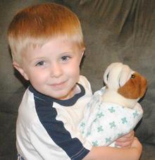 Children learn what they live: boy nurtures toy dog 